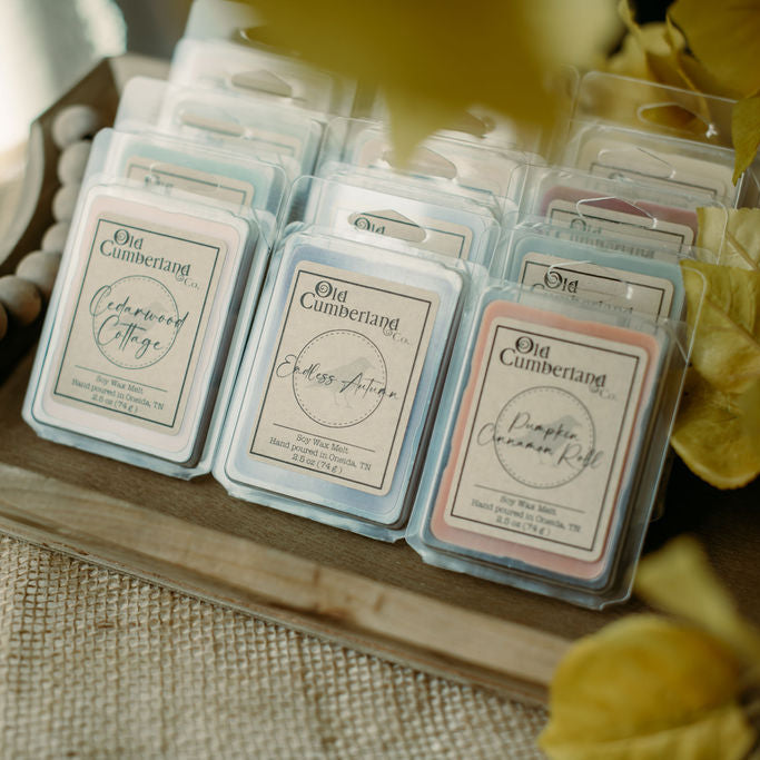 Packaged wax melts on a wooden tray with decorative elements